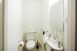 a white bathroom with a toilet and a sink at Cozy 1 bedroom at Notting Hill in London