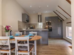 a kitchen and dining room with a wooden table and chairs at The Old Post Office in Canterbury