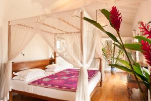 a bedroom with a bed with a canopy at A 03 Bedroom Villa in Galle Fort with Roof Terrace & Pool in Galle