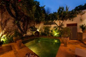 a swimming pool in the middle of a garden at A 03 Bedroom Villa in Galle Fort with Roof Terrace & Pool in Galle