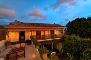 a house with a balcony at dusk at A 03 Bedroom Villa in Galle Fort with Roof Terrace & Pool in Galle