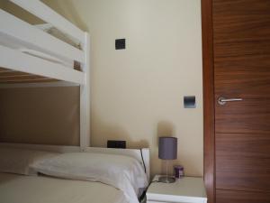 1 Schlafzimmer mit 2 Etagenbetten und einem Tisch mit einer Lampe in der Unterkunft Tarragona Ciudad, El Serrallo AP-1 in Tarragona