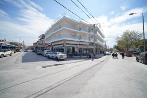 a large white building on a city street with cars at Hotel Olympion in Potos