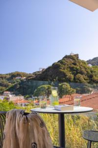 a table with two glasses and a bag on it at Erato by Samian Mare in Karlovasi