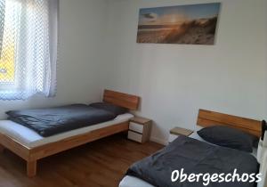 1 dormitorio con 2 camas y ventana en APARTMENT MONTEURZiMMER AM BAHNSTEIG en Kuppenheim
