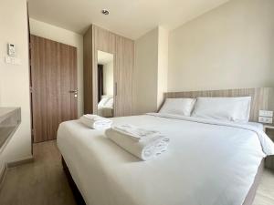a bedroom with a large white bed with towels on it at TheView Chaengwattana14 เดอะวิวแจ้งวัฒนะ14 in Bangkok
