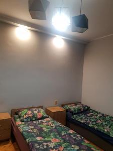 a room with two beds and lights on the wall at KWATERY PRACOWNICZE in Środa Wielkopolska