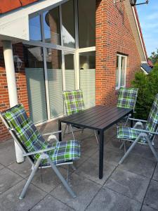 a picnic table and two chairs on a patio at Ferienhaus Fam. Mersmann in Papenburg