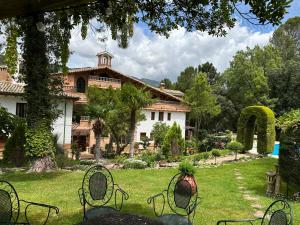 una casa con un patio con sillas delante en Hotel Rural Convento Santa Maria de la Sierra, en Arroyo Frío