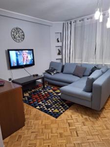 Il comprend un salon doté d'un canapé et d'une télévision à écran plat. dans l'établissement KWATERY PRACOWNICZE, à Środa Wielkopolska