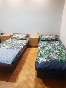 two beds sitting next to each other in a room at KWATERY PRACOWNICZE in Środa Wielkopolska