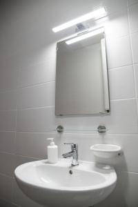 a bathroom with a white sink and a mirror at Rozmaring Apartmanház in Mórahalom
