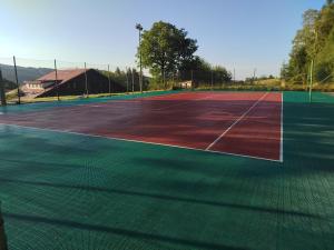 una pista de tenis de color rojo y verde en Penzion U kováře - vedlejší budova, en Nový Hrádek