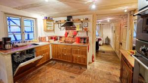 a large kitchen with wooden cabinets and a stove at Remparts de Riquewihr - Le Dragon Porte-Bonheur in Riquewihr