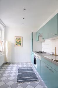 a kitchen with blue cabinets and a tile floor at R7 Berlin in Berlin