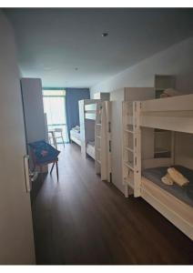 Zimmer mit 2 Etagenbetten und einem Schreibtisch in der Unterkunft Estelada Boarding Houses in München