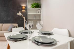 a white table with plates and wine glasses on it at Uus 30 Apartments in Tallinn