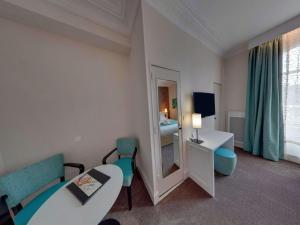 a hotel room with a mirror and a bed at Best Western Hôtel d'Arc in Orléans