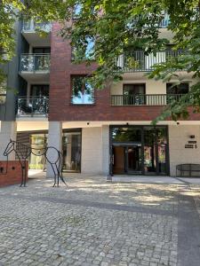 two benches sitting in front of a building at Maya's Flats & Resorts 80 - Garnizon Gdansk in Gdańsk