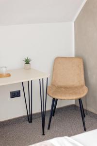 a chair sitting next to a table in a room at Complex Acom in Baile Felix