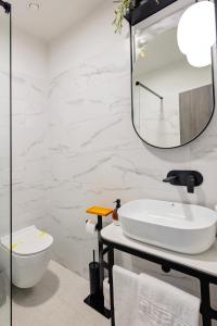 Baño blanco con lavabo y espejo en Complex Acom, en Băile Felix