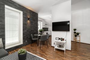 a living room with a table and a tv on a wall at Beautiful Apartments With Parking In a Quiet Location in Ostrava