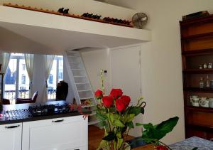 una cocina con una cama elevada y rosas rojas en Antwerpen perfect location, en Amberes