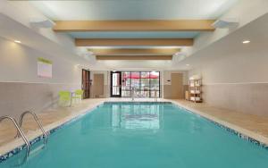 a large swimming pool in a hotel room with a pool at Home2 Suites by Hilton Tuscaloosa Downtown University Boulevard in Tuscaloosa