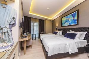 a hotel room with two beds and a desk at Barbera Hotel in Istanbul