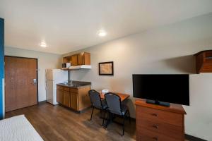 um pequeno quarto com uma cozinha e uma televisão em WoodSpring Suites Fort Worth Fossil Creek em Fort Worth