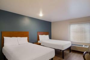 a hotel room with two beds and a window at WoodSpring Suites Jacksonville I-295 East in Jacksonville
