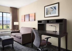 Habitación de hotel con escritorio y sofá en Homewood Suites by Hilton Cathedral City Palm Springs, en Cathedral City