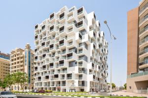 biały budynek z balkonami w obiekcie Furnished Studio In Binghatti Apartments, Dso w Dubaju