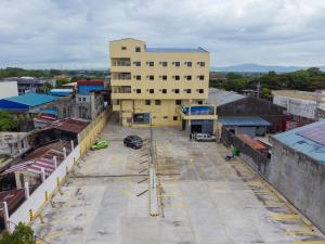 an empty parking lot in front of a building at Sundaze Dormitel in Naga