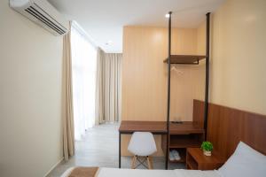 a bedroom with a desk and a bed and a chair at Sundaze Dormitel in Naga