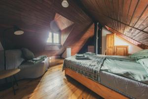 a bedroom with a bed and a couch in a room at Stara Kuźnia- Domek w Puszczy Noteckiej in Zatom Nowy