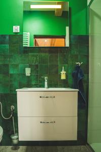 a bathroom with a sink and a green wall at Jałowcówka Centrum Aktywności Psychoruchowej in Koszarawa