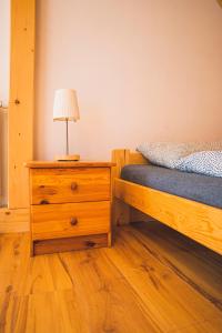 a bedroom with a bed and a lamp on a dresser at Jałowcówka Centrum Aktywności Psychoruchowej in Koszarawa