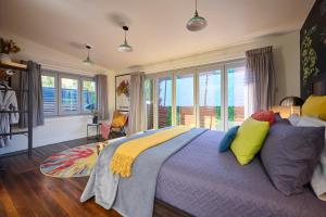 a bedroom with a purple bed with colorful pillows at Studio 22 Bellingen in Bellingen