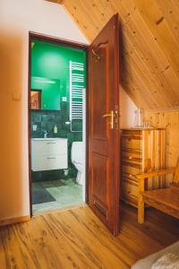een badkamer met een toilet, een wastafel en een deur bij Jałowcówka Centrum Aktywności Psychoruchowej in Koszarawa
