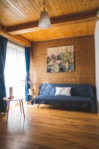 a blue couch in a room with a wall at Jałowcówka Centrum Aktywności Psychoruchowej in Koszarawa