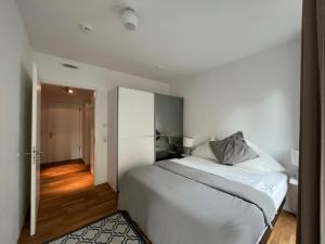 Modern Apartment in Mitte في برلين: غرفة نوم بسرير ابيض كبير وممر
