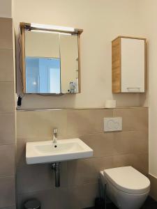 a bathroom with a sink and a toilet and a mirror at Modern Apartment in Mitte in Berlin