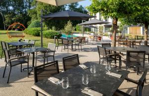 a group of tables and chairs with umbrellas at Domaine de Charmeil in Saint-Quentin-sur-Isère
