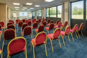 uma sala cheia de cadeiras vermelhas numa sala de aula em Domaine de Charmeil em Saint-Quentin-sur-Isère