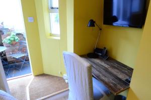 a room with a table with a television and a chair at The Jericho Studio in Oxford