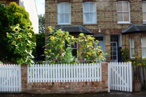 a white picket fence in front of a house at The Jericho Studio in Oxford