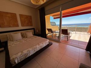 a bedroom with a bed and a view of the ocean at Terrazas de Jandía in Morro del Jable