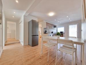uma cozinha com uma mesa e cadeiras e um frigorífico em RAJ Living - 3 Room Apartments - 20 Min to Messe DUS & Old Town DUS em Meerbusch