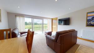 a living room with a couch and a table and chairs at Meadow View in Crawley